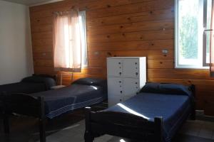 埃尔卡拉法特Folk Suites的配有木墙和窗户的客房内的两张床