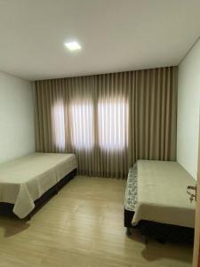 塞蒂拉瓜斯Sítio Gilmar2filhas的一间卧室设有两张床和窗户。