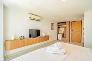 纳塔尔Vip Praia Hotel的一间设有床铺、电视和毛巾的客房