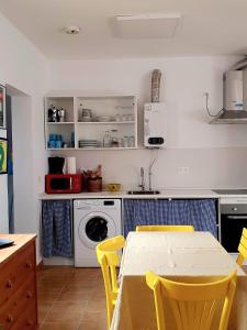 厄尔·波索·德·洛斯·弗莱尔Vivienda rural en Cabo de Gata的厨房配有桌子和洗衣机。