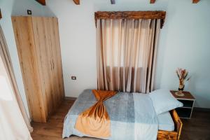 吉诺卡斯特Bujtina ANLU的一间卧室配有床和带窗帘的窗户