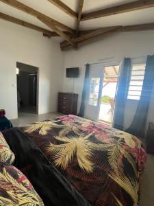 Fond Belle FontaineKaz Karaîb'的一间卧室配有一张大床和色彩缤纷的毯子