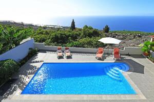 蒂哈拉费Ferienhaus für 6 Personen ca 105 qm in La Punta, La Palma Westküste von La Palma的一个带椅子的游泳池,享有海景