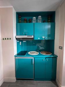 拉马格德莱伊内ComeCasa La Magdeleine 2 Bedrooms Chalet的蓝色的厨房配有炉灶和蓝色橱柜