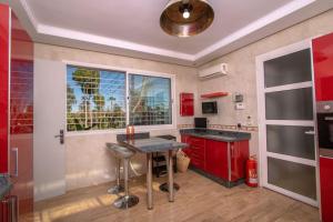 Oulad TayebVilla Meriem, Fès的厨房配有红色橱柜、桌子和窗户