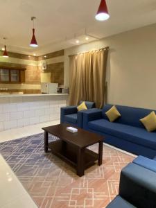 艾卜哈الخيال للوحدات السكنية的客厅配有蓝色的沙发和咖啡桌