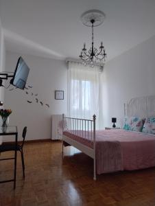 安科纳La Casa di Giulia的一间卧室配有一张床、一台电视和吊灯。