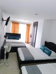 伊瓦格Hotel Bolivariano AV的酒店客房设有两张床和窗户。