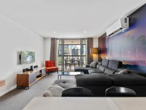 布里斯班Discover urban bliss in our 1-bedroom apartment! City views and cultural gems.的带沙发和电视的客厅