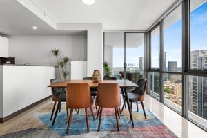 悉尼Central 2-Bed with Parking & Stunning Views的一间带桌椅和大窗户的用餐室