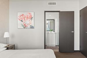 悉尼Central 2-Bed with Parking & Stunning Views的白色卧室配有床和镜子