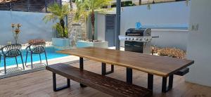 瓜纳卡斯特Playa Potrero - modern 3 BR home centrally located - Casa Coastal Serenity的木制长凳,位于带炉灶的木甲板上