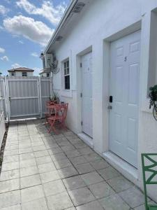 迈阿密Nice and Cozy guest house 4的白色的房子,两扇门和天井上的一张桌子