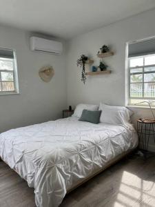 迈阿密Nice and Cozy guest house 4的白色卧室内的一张白色床,设有2个窗户