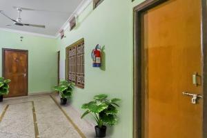 布巴内什瓦尔OYO Hotel Sai Heritage的走廊上种有盆栽植物,门上有一扇门