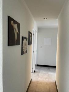 Villa NuevaApartamento cómodo y exclusivo的走廊上墙上挂有照片