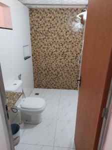 孔塔任Casa simples e aconchegante / Banho quente的一间带卫生间和木墙的浴室