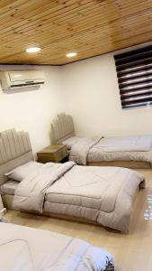 卡拉克شاليه نايا的一间带三张床的卧室和木制天花板