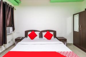 贾姆穆OYO Flagship 62748 Hotel Zeenat的一间卧室配有一张带红色枕头的大床
