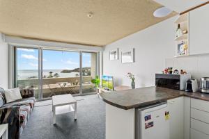 悉尼Apartment with Pool Access, a minute to the Beach的厨房和客厅,享有海景