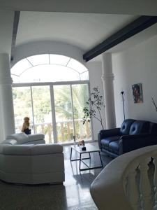 特古西加尔巴Habitación con balcón en una Mansión的客厅设有两张沙发和一个大窗户