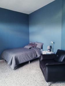 特古西加尔巴Habitación con balcón en una Mansión的蓝色卧室,配有床和椅子