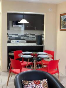 危地马拉Cozy and relaxing apartment的一间厨房,里面配有桌子和红色椅子