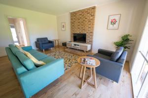 米尔迪拉The Royal Cottage的客厅配有2张蓝色沙发和电视