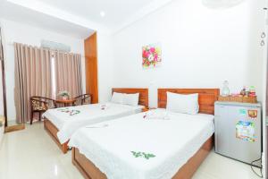 归仁Khách sạn Ciao Quy Nhơn的一间带两张床的卧室和一台冰箱