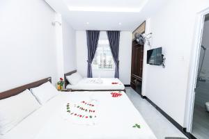 归仁Khách sạn Ciao Quy Nhơn的一间白色卧室,配有两张床和窗户
