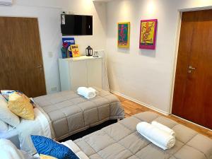 布宜诺斯艾利斯Alfonsina Hostel的小房间设有两张床和电视