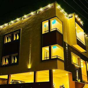 埃尔加德R Hotels By Suraj Residency Yercaud的一座晚上有灯的建筑