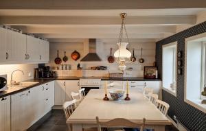 法尔松3 Bedroom Cozy Home In Farsund的厨房配有桌椅和吊灯。