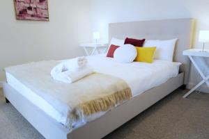 博士山Lovely Home in midtown Box Hill with two bedrooms的一张大白色的床,上面有色彩缤纷的枕头
