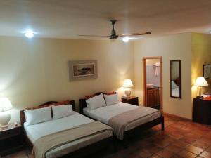 圣何塞弗朗西斯科公寓酒店的一间卧室配有两张床、两盏灯和一面镜子