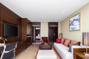 海口海南新燕泰大酒店的客厅配有白色沙发和电视