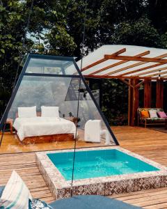 MacasMacas Glamping的一个带床和玻璃房子的游泳池
