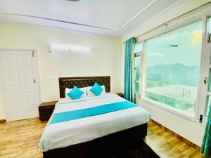 西姆拉Royal Green Valley View Mashobra的一间卧室设有一张大床和大窗户