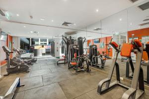 墨尔本Chic Studio Apartment in Melbournes CBD的健身房设有跑步机、椭圆机和镜子