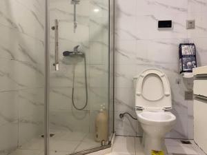 杭州时光印记青年旅舍的一间带卫生间和玻璃淋浴间的浴室