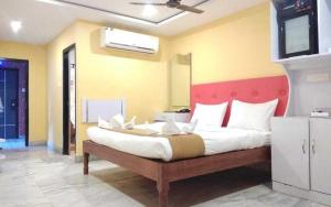 布莱尔港OYO Hotel Nico的一间卧室配有一张大床和红色床头板