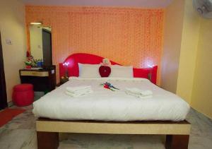布莱尔港OYO Hotel Nico的一间卧室配有一张大床和红色床头板