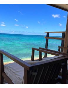 HauulaHummingbird Oceanfront Cottage的海滩上的长凳,享有海景