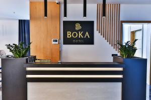 科托尔Hotel Boka的大堂设有boda酒店标志和盆栽植物
