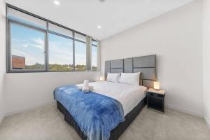 悉尼Two Bedroom Private Apartment In Lane Cove with Parking的一间卧室设有一张大床和两个窗户。