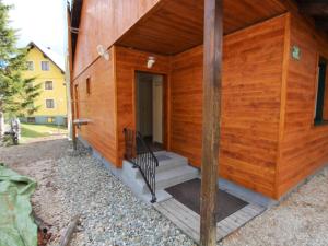 图拉彻霍赫Sunlit Cabin with Jacuzzi in Turracherhohe的一座带门廊和楼梯的木制建筑