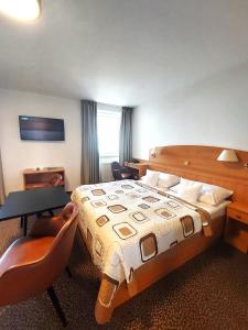 布拉格艾维酒店的酒店客房带一张床、一张桌子和椅子