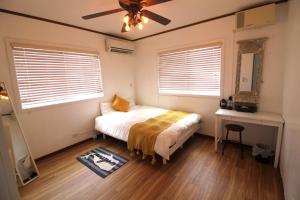 嘉手纳冲绳威尔酒店的一间卧室配有一张床和吊扇