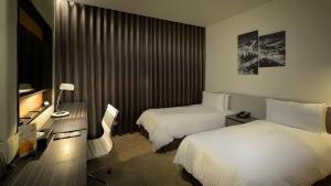 台南荣美金郁金香酒店的酒店客房设有两张床和电视。