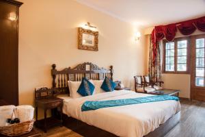 西姆拉Shimla British Resort的一间卧室配有一张带蓝色枕头的大床